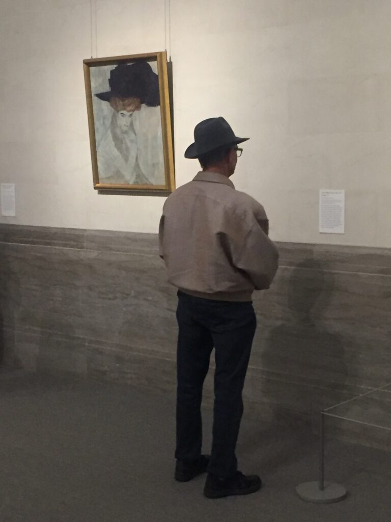 Reference photo showing Gustav Klimt's painting and a viewer