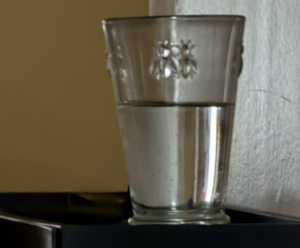 Glass of water with one edge disappearing because its value closely matches the background—an example of how artists see subtle value relationships.
