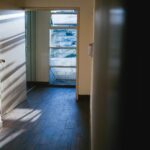 Open doorway with sunlight falling across a wooden floor and walls beyond